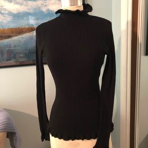 Black sweater, ruffled neck & sleeves.